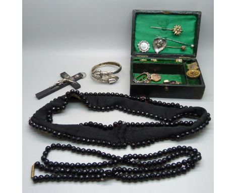 A Victorian jewellery box containing brooches, stick pins, an enamelled buckle, French jet, beads, bangle, a belt, etc. 