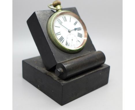 A military issue pocket watch on a black stand, marked Patt. 300, 4141, with broad arrow 