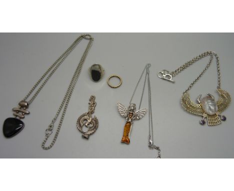 Three silver pendants and chains, one set with Baltic amber, one other silver pendant and a ring 