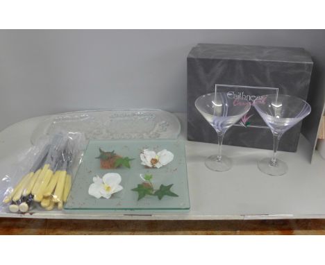 A glass oblong display plate with two sheep, a glass table decoration, fish knives and forks and steak knives and forks and a