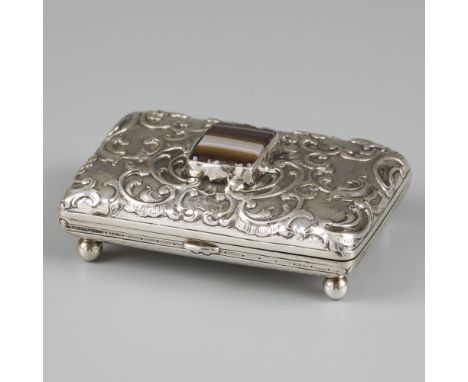 Cigarette / tobacco box silver. Lid decorated with rocailles and set with agate. The bottom is hammered. Standing on four bal