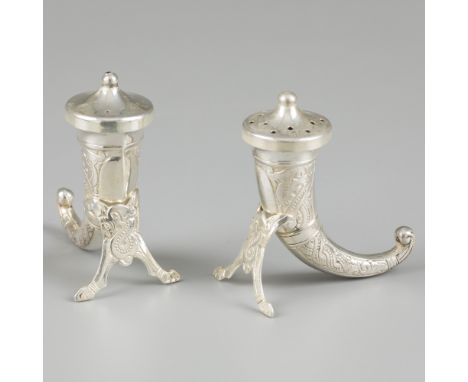 Pepper and salt shaker silver. Made in the shape of a Viking horn with legs and removable cap. Decorated with engraved detail