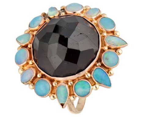 14K Yellow gold cocktail ring with garnet in an entourage of opal. Set with a round faceted garnet and 14 cabochon cut opals.