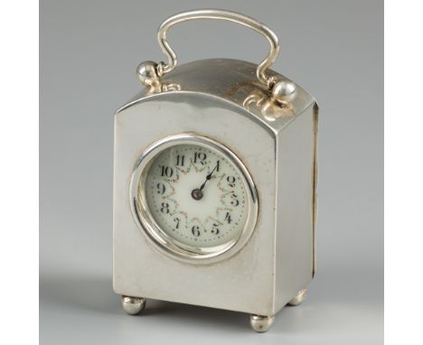 Desk clock silver. Sleek design. The top is semicircular with a handle. Standing on four ball feet. The timepiece is in good 