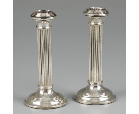 2-piece set of candlesticks silver. With pillar-shaped fluted trunk and filled base. The Netherlands, Amsterdam, Bierenbroods