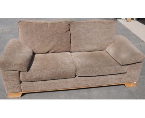 A large two seat sofa with light wood supports upholstered in oatmeal fabric (width 196cm) 