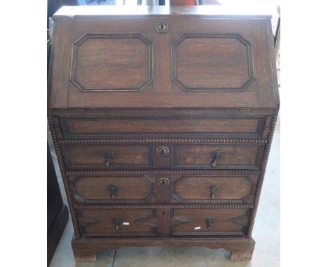 19th C oak bureau with panelled fall front revealing fitted interior above three drawers, on bracket supports, with heavy bra
