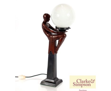 An Art Deco style bronzed table lamp in the form of a seated lady holding a globe shade, 51cm high 