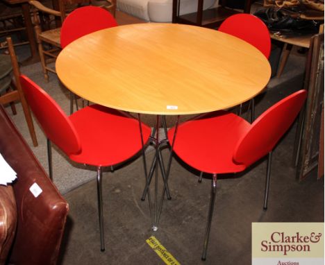 A modern design circular light wood and chrome kitchen table, and four matching red and chrome shaped back chairs 
