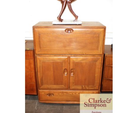 A light Ercol secretaire cabinet, drop flap compartment above cupboards and single drawer below, raised on castors, 82cm wide