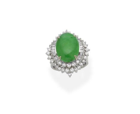 A jade and diamond dress ringThe oval jade cabochon within an undulating surround set with brilliant and step-cut diamonds,  