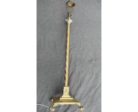 An early 20th century brass telescopic Corinthian column standard lamp, raised on square base with lion paw feet CONDITION RE