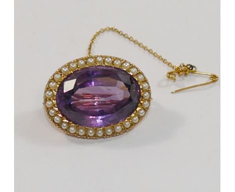 A Victorian oval amethyst and half pearl brooch, the oval mixed cut amethyst, in open back setting within half seed pearl sur
