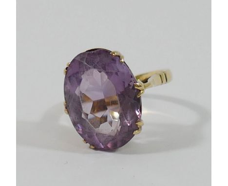 An amethyst single stone ring, the oval mixed cut stone 17mm x 13mm, within claw setting above an open gallery, all set in ye