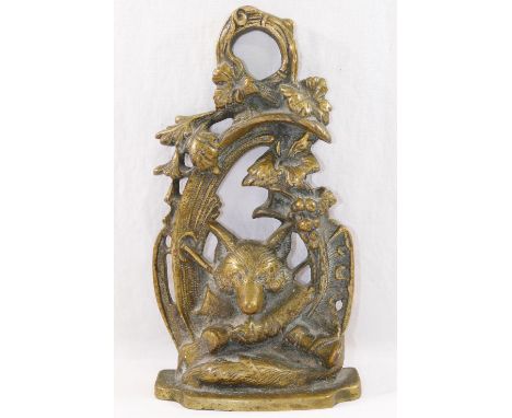 A 20th century brass door stop, cast with a fox mask and hunting regaila within a scroll surround, 27cm high CONDITION REPORT