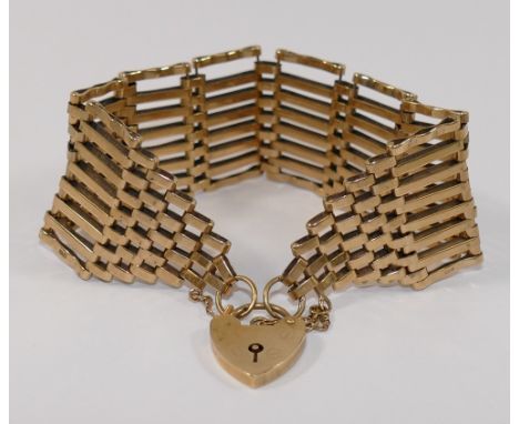 A large 9 carat gold gate link bracelet, with heart-shaped padlock clasp, London 1976, 2.2cm wide, 27.1g CONDITION REPORT: Pl