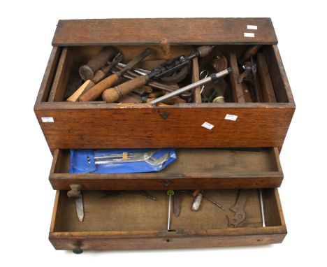 An vintage wooden tool box and contents. The box with two drawers to the front and a lift out tray, containing chisels, malle