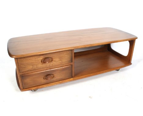 A mid-century mobile Ercol coffee table. With two short drawers and an open shelf beneath. L125cm x D53cm x H40cm Condition R