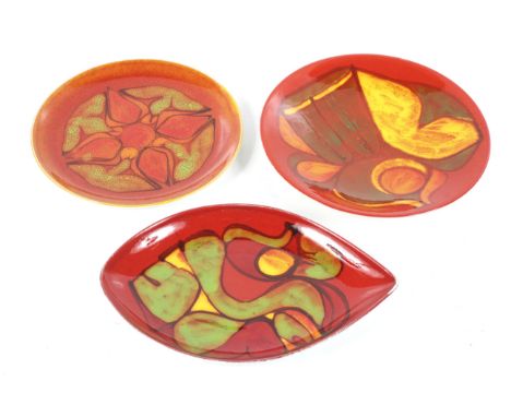 Three mid-century Poole Pottery Delphis plates. Comprising two circular and a shield shaped plates. Max. diameter 26cm