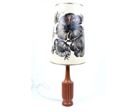 Mid century wooden table lamp and shade. A fluted bottle shaped base with a tall floral print shade. Total height 76cm