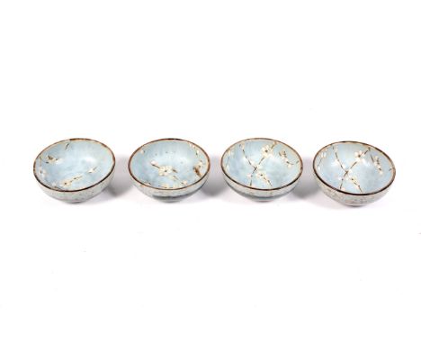 A set of four contemporary Japanese studio pottery rice bowls. Decorated with stylized cherry blossom on a light blue ground.