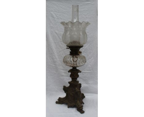 A Victorian oil lamp with an etched glass shade, faceted glass reservoir and a leaf scrolling bronze base, 70cm high includin