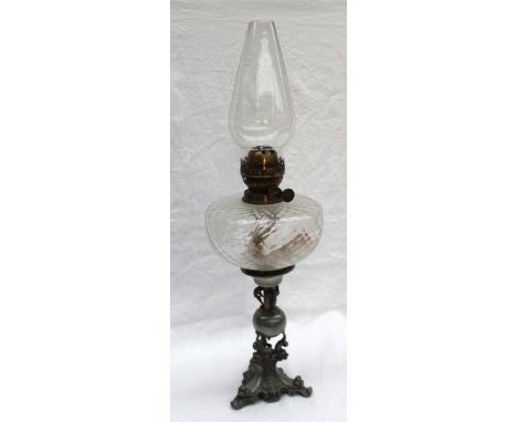 A Victorian electroplated oil lamp with a moulded clear glass reservoir, the base with winged dragons, stylised dolphins and 