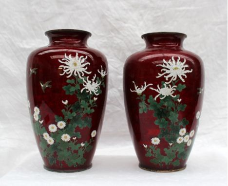 A pair of Japanese cloisonne enamel vases, decorated with chrysanthemums and leaves to a red ground, 18cm high 