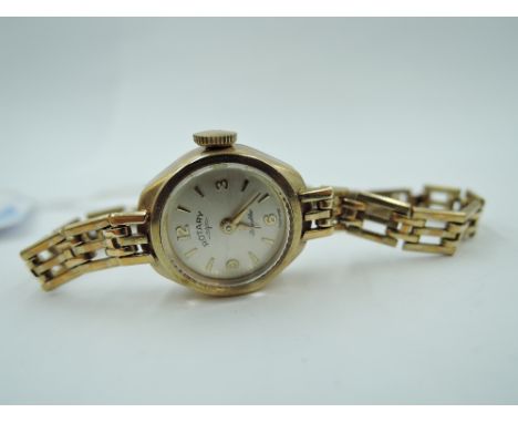 A lady's 9ct gold wrist watch by Rotary having a baton &amp; Arabic numeral dial to small face in 9ct gold case with gate bra