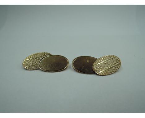 A pair of 9ct gold cufflinks having oval panels, chain connectors and engine turned decoration,  approx 3.4g