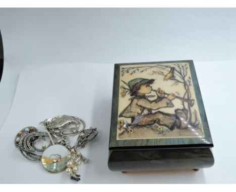 A wooden Hummel musical box containing eight costume brooches
