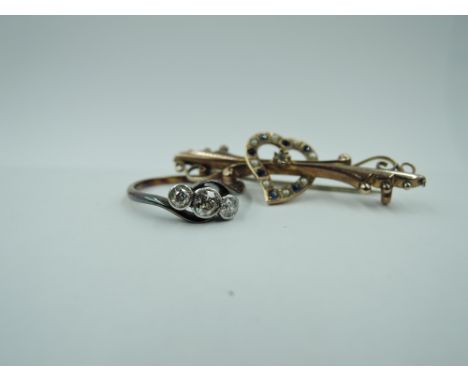 A diamond trilogy ring, total approx 0.38ct in collared mounts to cross over shoulders on a yellow metal loop stamped 18ct, s