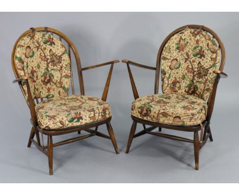 A pair of Ercol spindle-back easy chairs each with a loose cushion to the seat &amp; back, &amp; on tapered legs with spindle