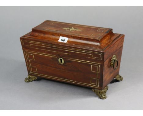A 19th century brass-inlaid rosewood tea caddy with a fitted interior enclosed by a hinged lid, with brass ring handles, &amp