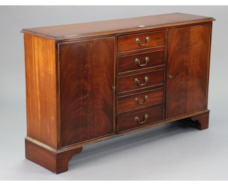 A mahogany low sideboard fitted five long drawers flanked by a cupboard either side, on bracket feet, 53½” wide x 32” high x 