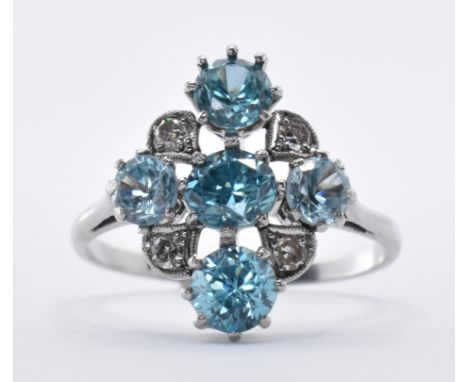 A platinum blue zircon and diamond cluster ring being prong set with four round cut zircon stones and illusion set with four 