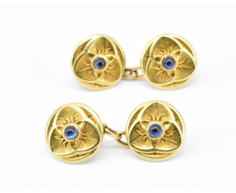 A pair of Art Nouveau 18ct gold cufflinks each being set with blue sapphire cabochons within foliate trefoil design heads, un