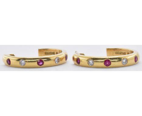 A pair of 18ct gold ruby and diamond hoop earrings having stud fastenings with open backs, being set with three round cut rub