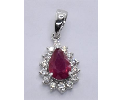A hallmarked 18ct white gold ruby and diamond pendant being set with a central pear cut ruby with a halo of round cut diamond
