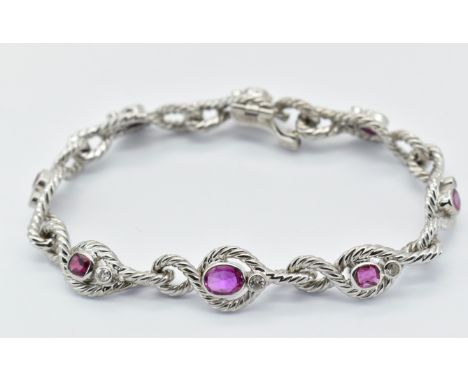 A French 18ct white gold ruby and diamond bracelet having rope twist design links set with oval cut rubies and round cut diam