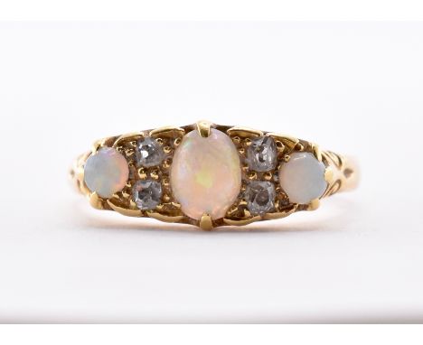 A gold opal and diamond ring having an oval head set with a central oval opal cabochon flanked by two further round opal cabo