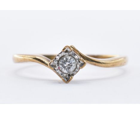 A hallmarked 9ct gold crossover ring being set with a round cut diamond in a square setting. Hallmarked Sheffield 2000. Weigh