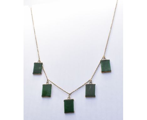 A Chinese 14ct gold green hardstone necklace. The necklace strung with five rectangular green hard stone stone panels united 