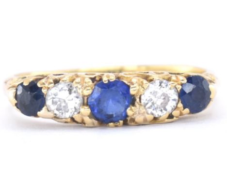 An 18ct gold sapphire and diamond ring. The ring set with three mixed cut sapphires and two old cut diamonds in a gypsy setti