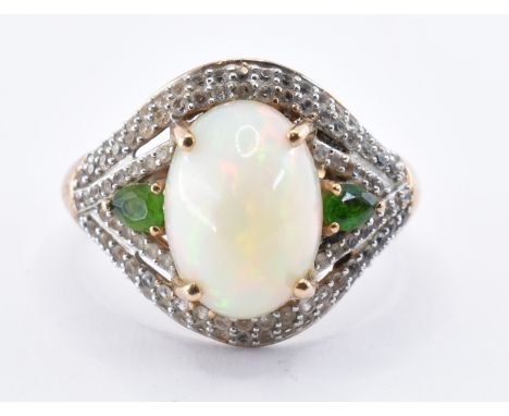 A stamped 9ct gold TJC ladies dress ring having a central opal cabochon flanked by two pear cut green stones and surrounded b