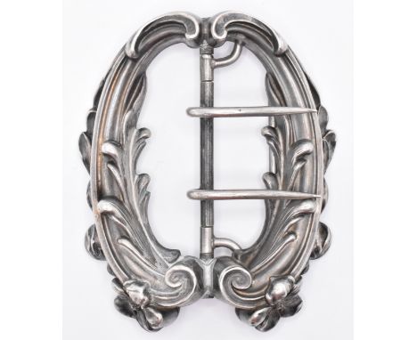 An Edwardian Art Nouveau silver belt buckle of symmetrical form with two moulded scrolls decoration with florals. Marked ster