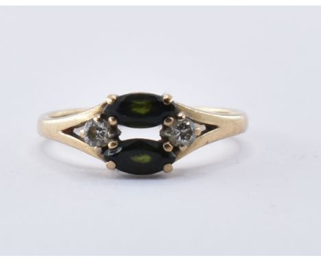 A hallmarked 9ct gold ring. The ring set with two marquise cut tourmalines flanked by two round brilliant cut diamonds within