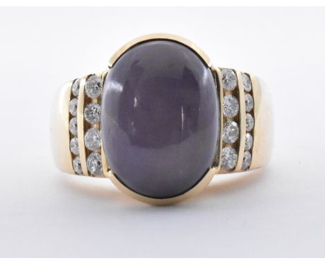 A 14ct gold star sapphire and diamond ring being set with a large blue star sapphire cabochon flanked by two rows of round cu
