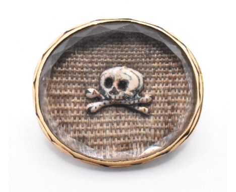 An 18th Century Stuart crystal mourning slide of oval form having a central panel of woven hair with an enamelled memento mor