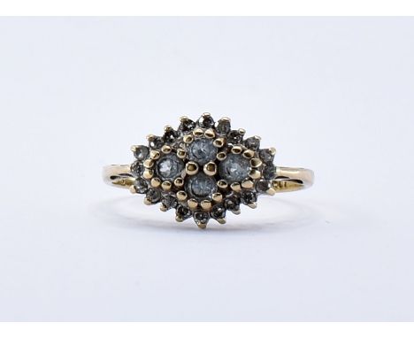 A 9ct gold cluster ring having four central round cut white stones held within raised claw settings surrounded by a halo of d